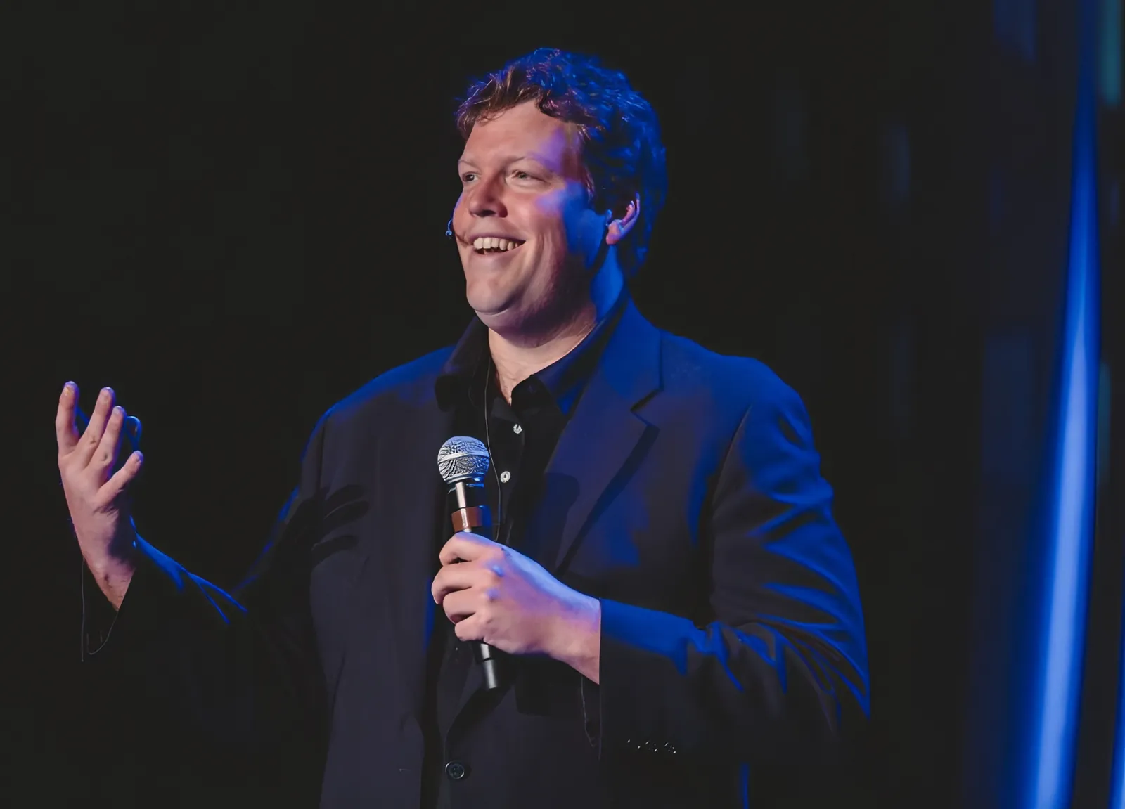 Kirk Drake speaking on stage with a microphone